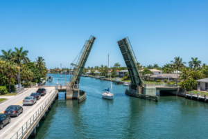 Raised drawbridge over the Intracoastal Waterway with a sailboat passing underneath